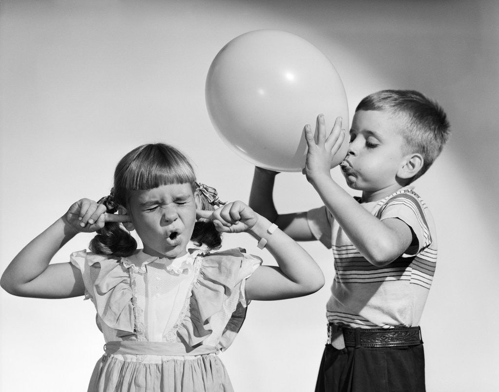 Detail of 1950s little boy blowing up big balloon little girl with fingers in ears eyes closed by Anonymous