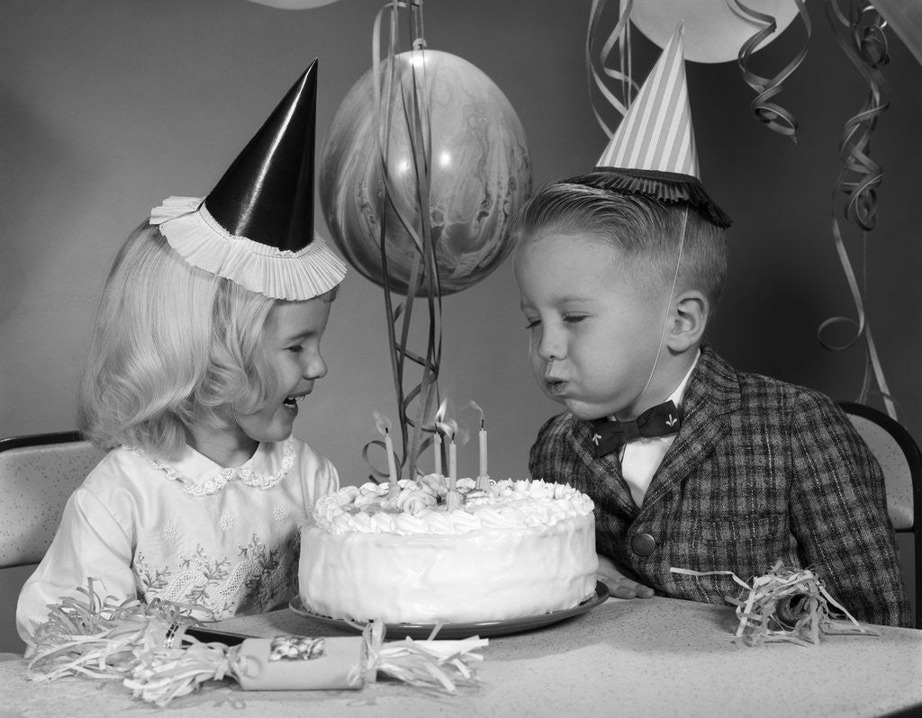 Detail of 1960s boy blowing out candles on birthday cake by Anonymous