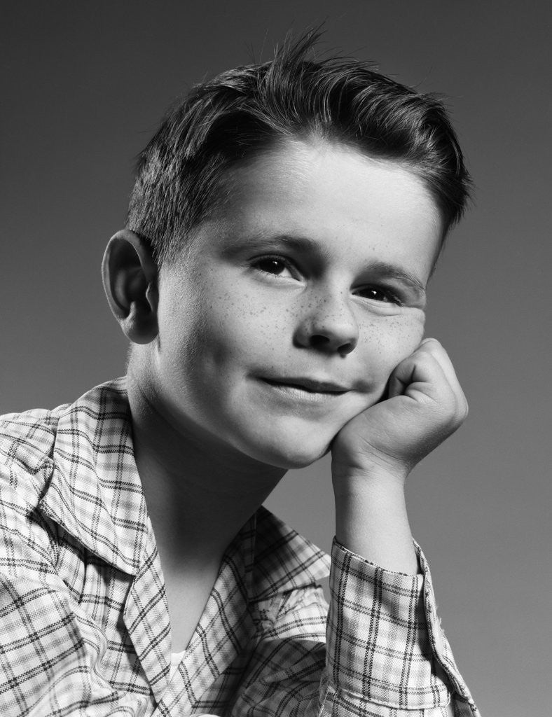 Detail of 1950s child portrait boy with freckles posed resting head cheek on hand by Anonymous