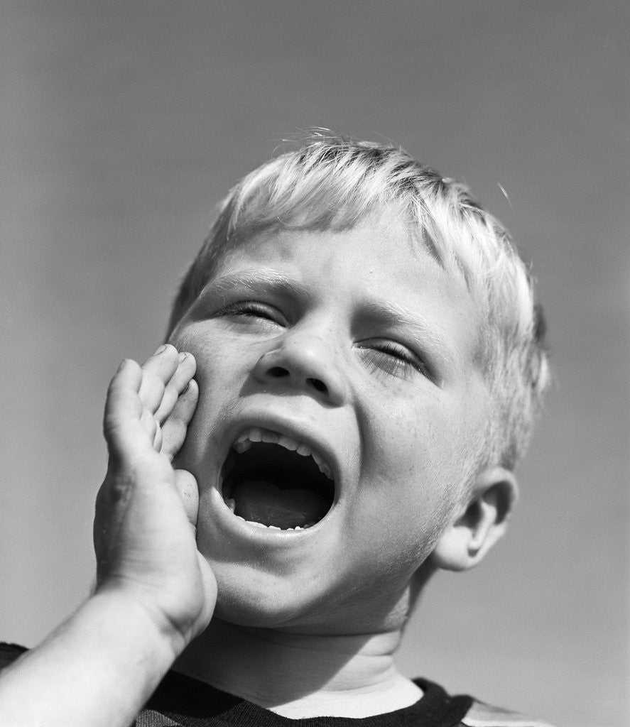 Detail of 1950s blond boy with eyes closed and hand cupping a wide open mouth shouting by Anonymous