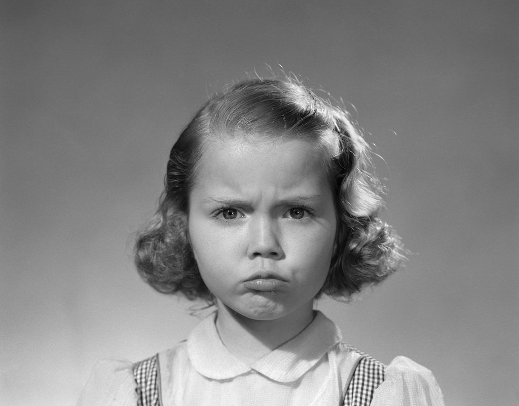 Detail of 1950s portrait sad serious girl making grumpy angry pouting facial expression looking at camera by Anonymous