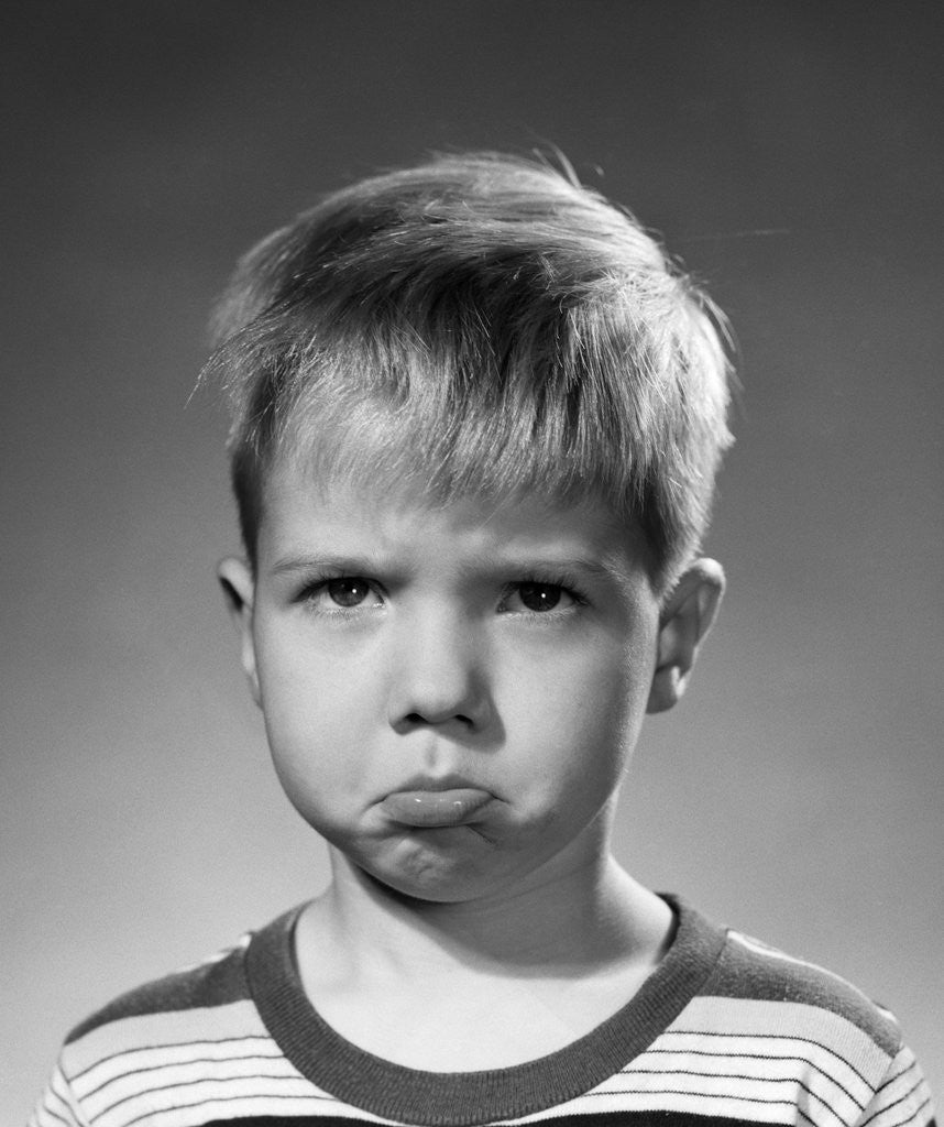 Detail of 1950s portrait blond boy sad grumpy angry pouting facial expression looking at camera by Anonymous