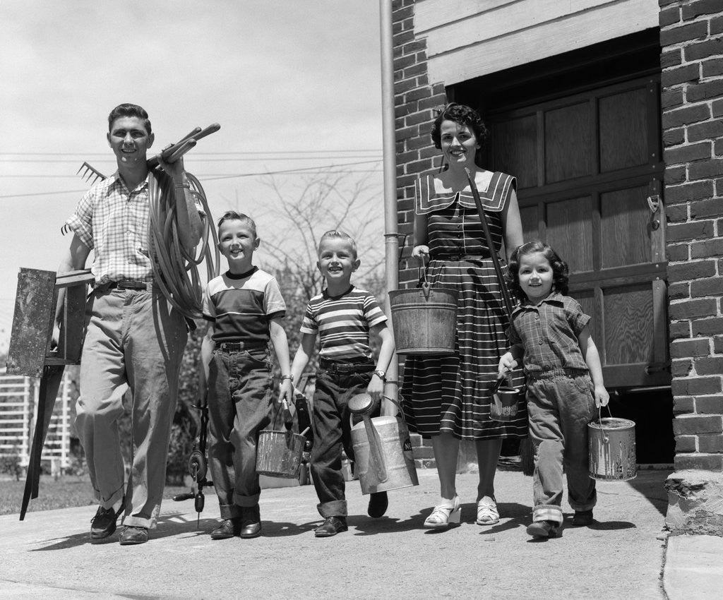 Detail of 1950s family mother father 3 children happy smiling carrying gardening home improvement tools by Corbis