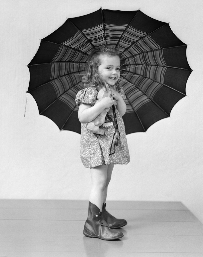 Detail of 1930s 1940s child smiling little girl holding rainy day umbrella by Anonymous