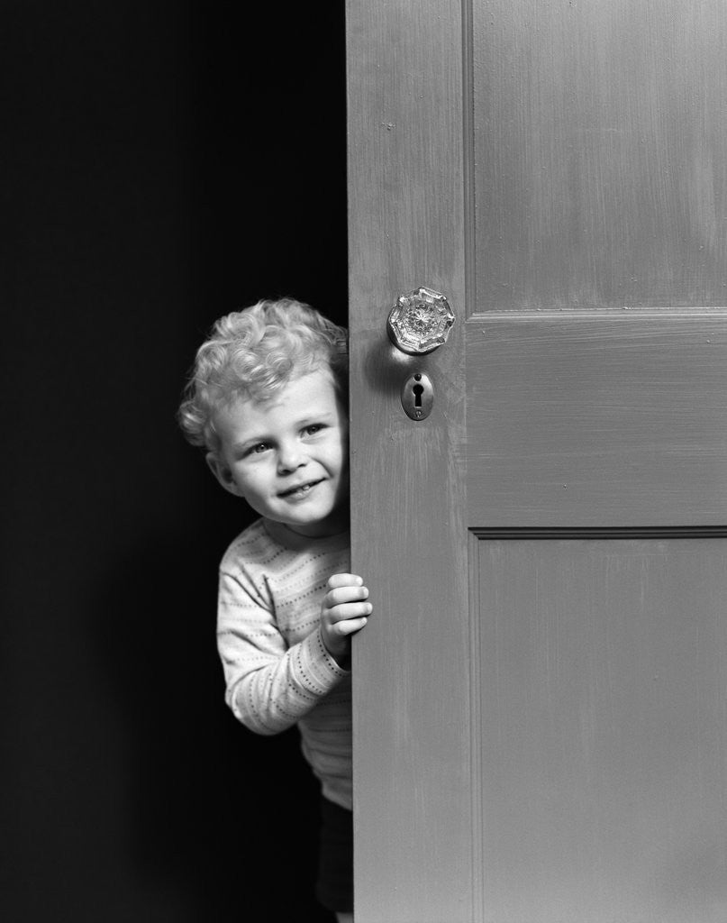 Detail of 1940s child little boy peeking looking around door by Anonymous