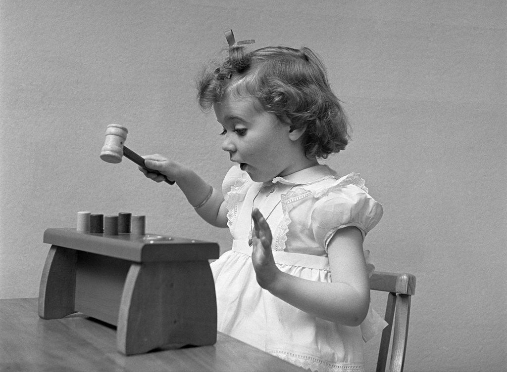 Detail of 1940s child little girl playing hammering toy game by Anonymous