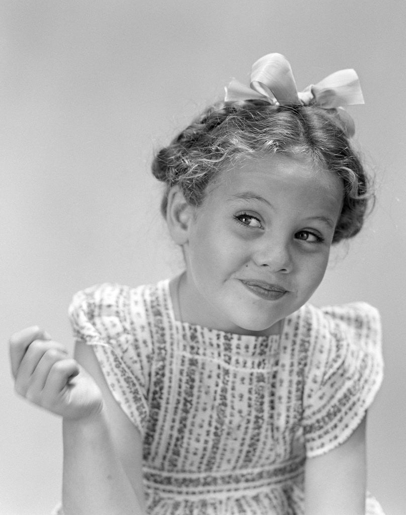 Detail of 1940s little girl smiling smirking looking off to one side by Anonymous