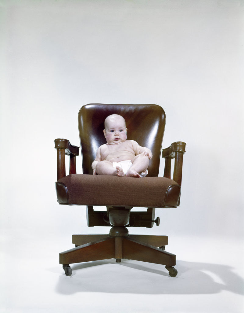 Detail of 1960s chubby baby in diaper sitting in office executive chair by Anonymous