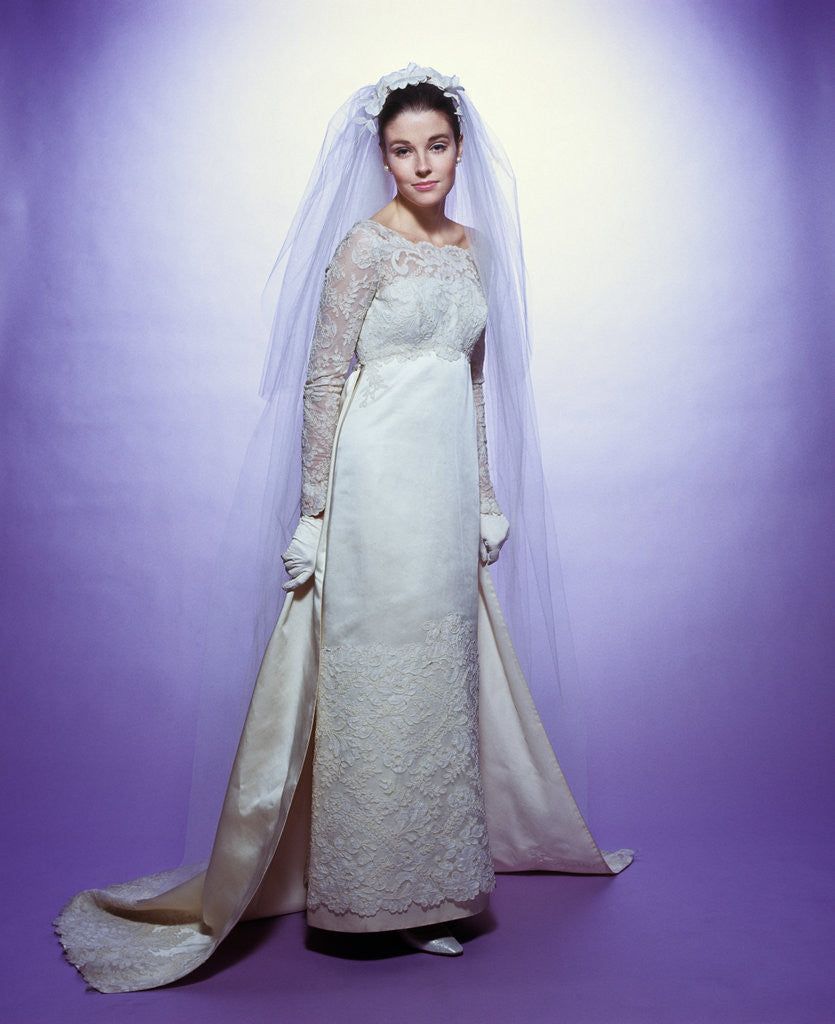 Detail of 1960s young woman bride portrait bridal veil empire waist gown lace bodice hem full length by Corbis