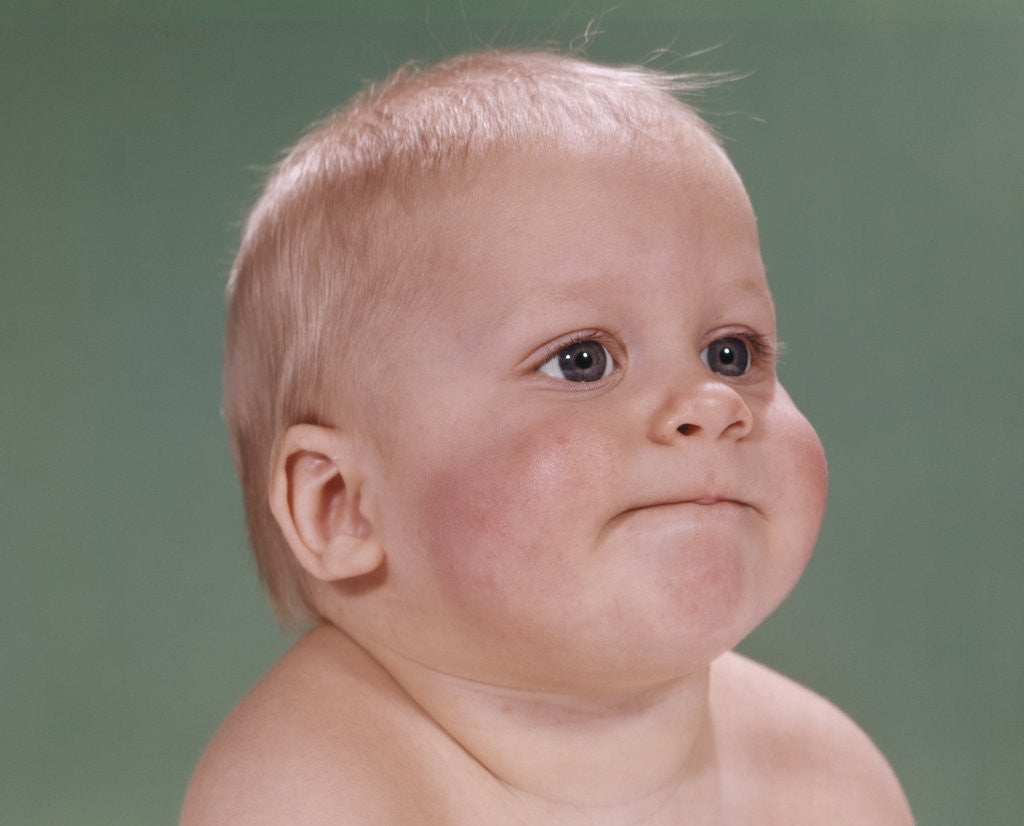 Detail of 1960s portrait of blond baby chubby cheeks with funny face expression by Anonymous