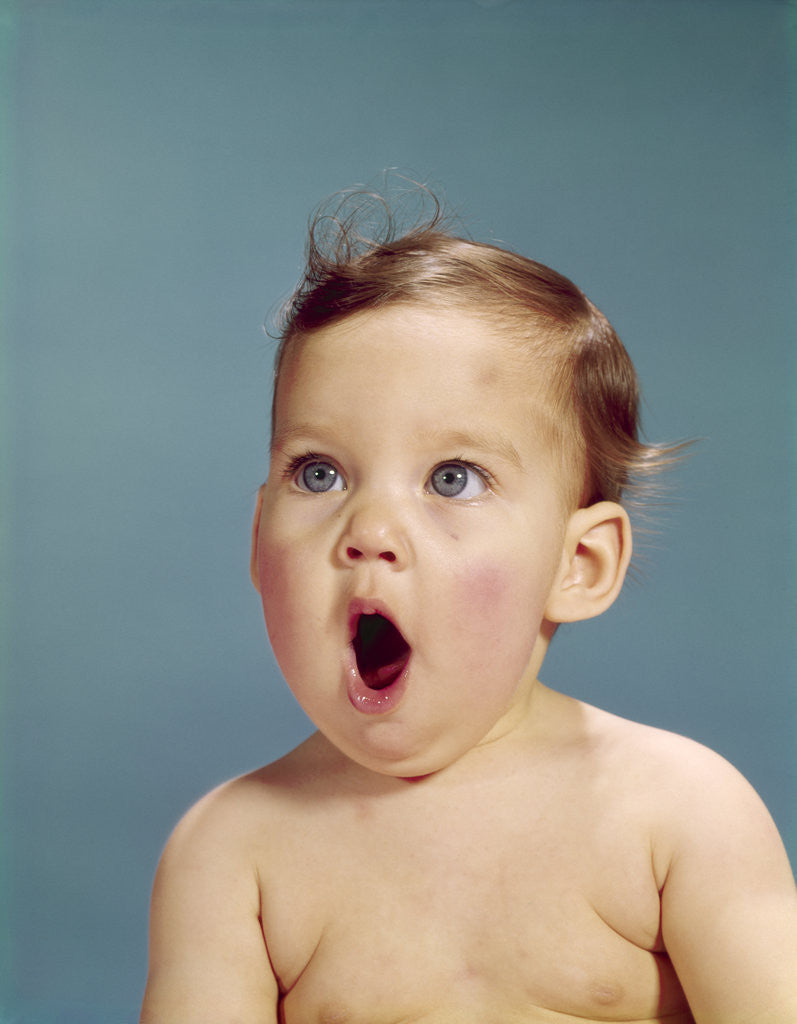 Detail of 1960s baby portrait mouth wide open shocked facial expression by Corbis