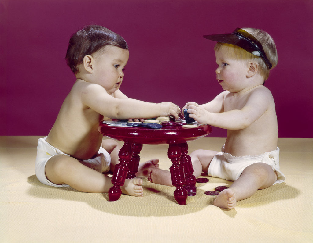 Detail of 1960s two babies sitting at red stool playing cards poker with gambling chips by Anonymous