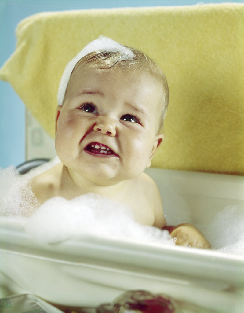 Detail of 1960s smiling baby in bath looking up by Anonymous