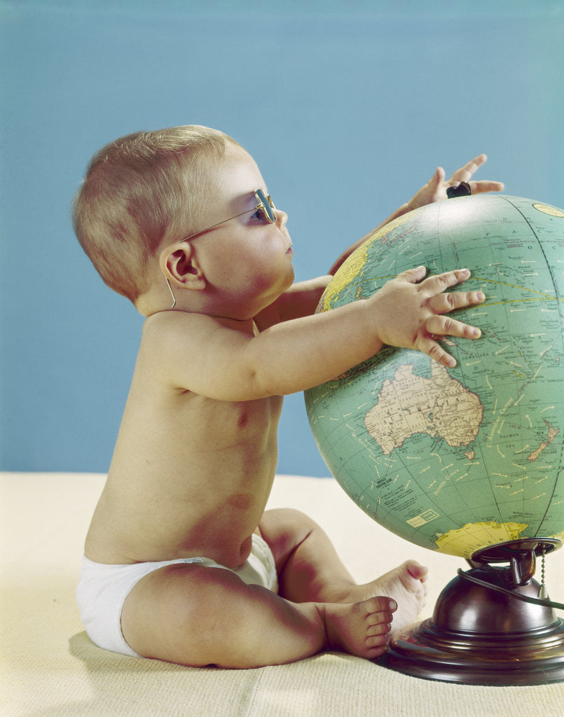 Detail of 1960s baby wearing eyeglasses hugging the world globe earth by Anonymous