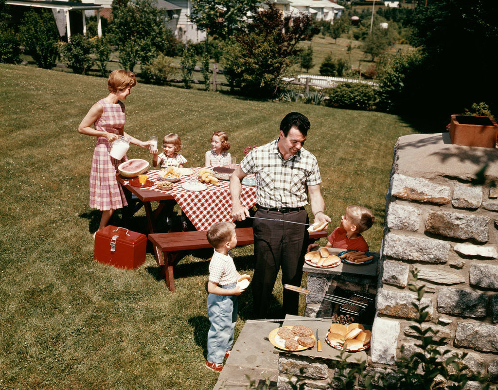 Detail of 1960s family father mother two daughters two sons backyard bar-b-cue outdoor by Anonymous