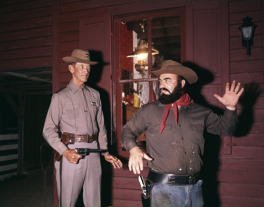 Detail of 1960s 1970s western sheriff arrests bearded cowboy about to draw gun by Corbis