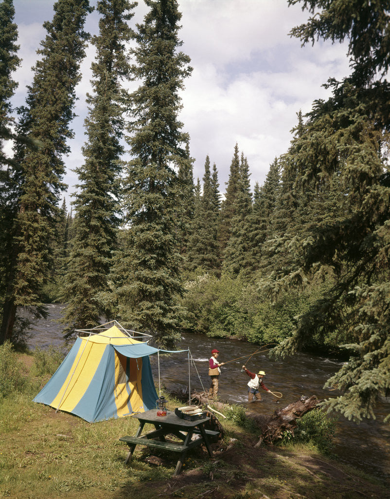 Detail of 1970s couple man woman fishing in stream campsite with tent by Anonymous