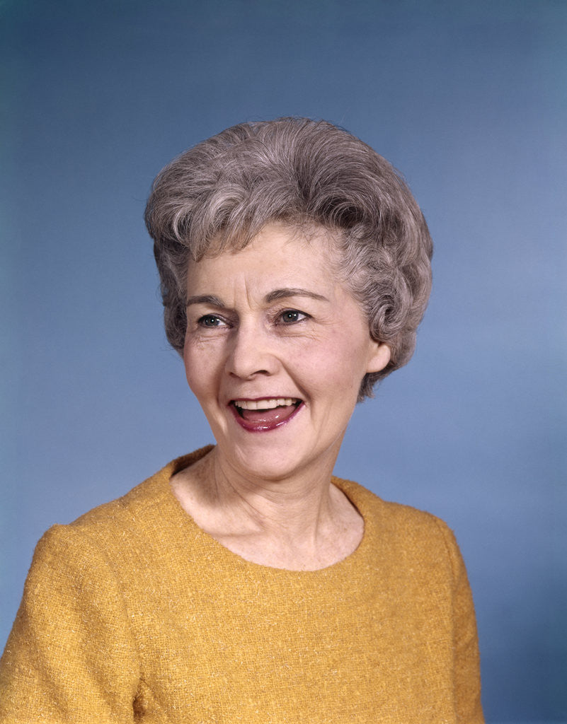 Detail of 1960s portrait smiling elderly woman wearing orange top laughing looking to side by Anonymous