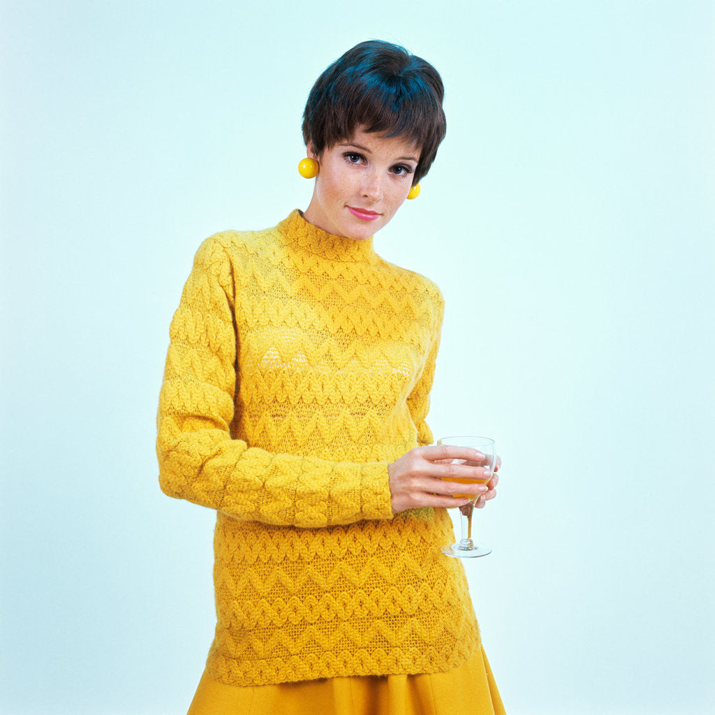 Detail of 1960s brunette woman short pixie hair style yellow knit sweater earrings holding wine glass by Anonymous