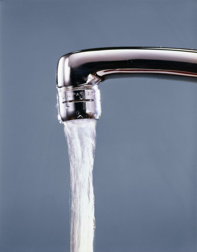 1990s water pouring from metal kitchen faucet by Corbis