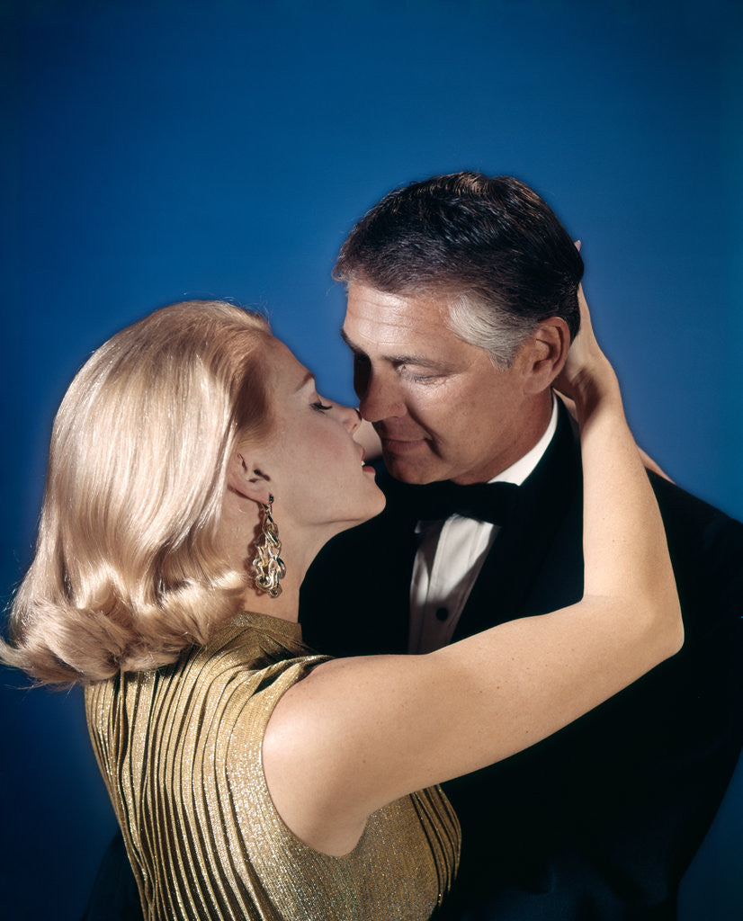 Detail of Romantic couple embracing about to kiss husband wife evening dress studio 1970s 1960s by Anonymous