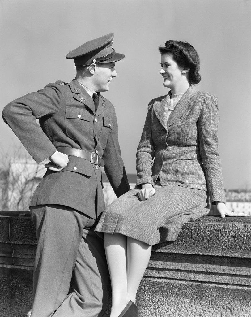 Detail of 1940s happy couple man wearing army uniform woman sitting on stone wall by Anonymous
