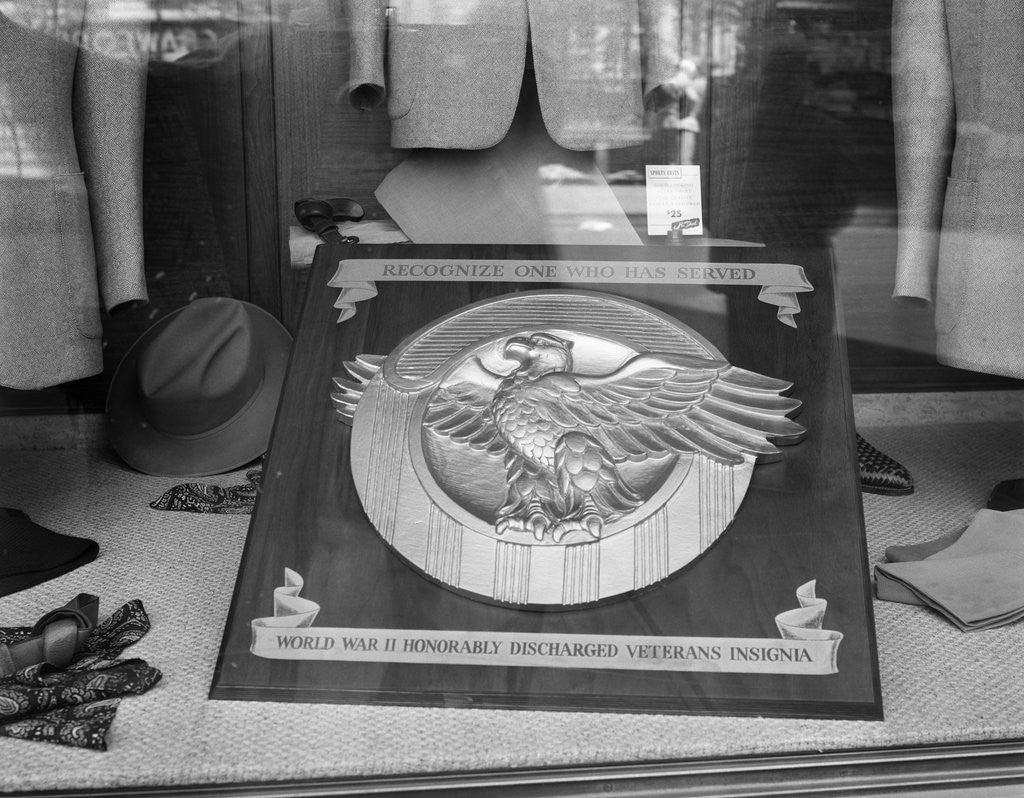 Detail of 1940s 1945 plaque of the war veterans honorable discharge button insignia in store window by Anonymous