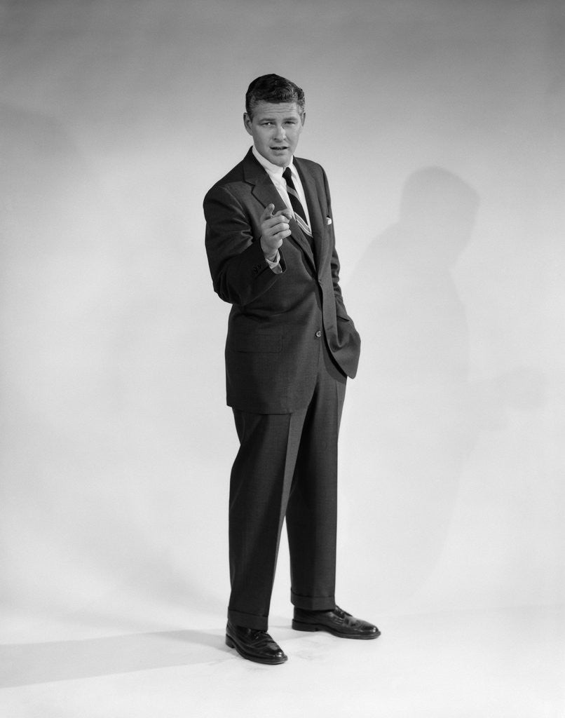 Detail of 1960s man in business suit standing pointing finger looking at camera by Anonymous