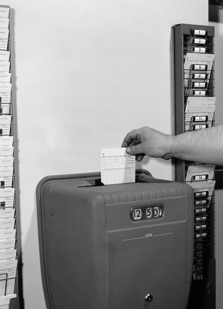 Detail of 1950s man's hand punching time card by Anonymous