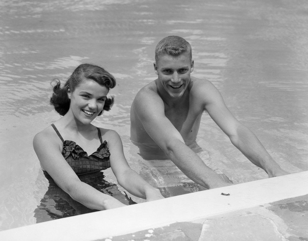 Detail of 1950s teen couple in swimming pool smiling looking at camera by Anonymous