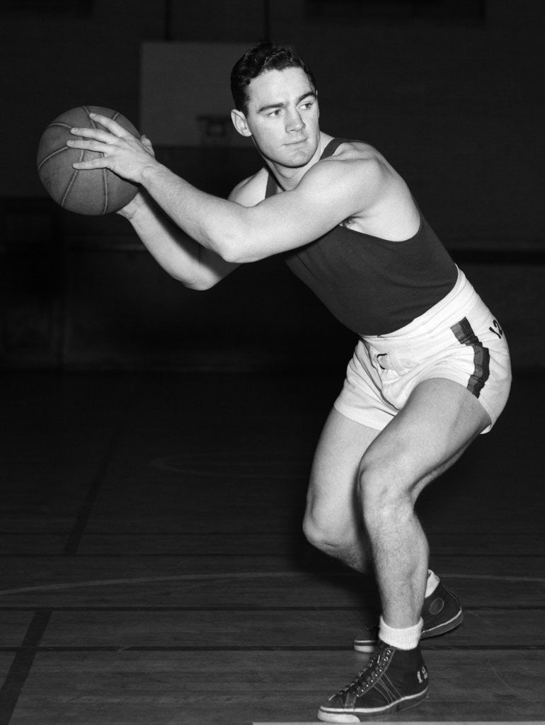 Detail of 1930s teen boy playing basketball holding ball standing in position by Anonymous