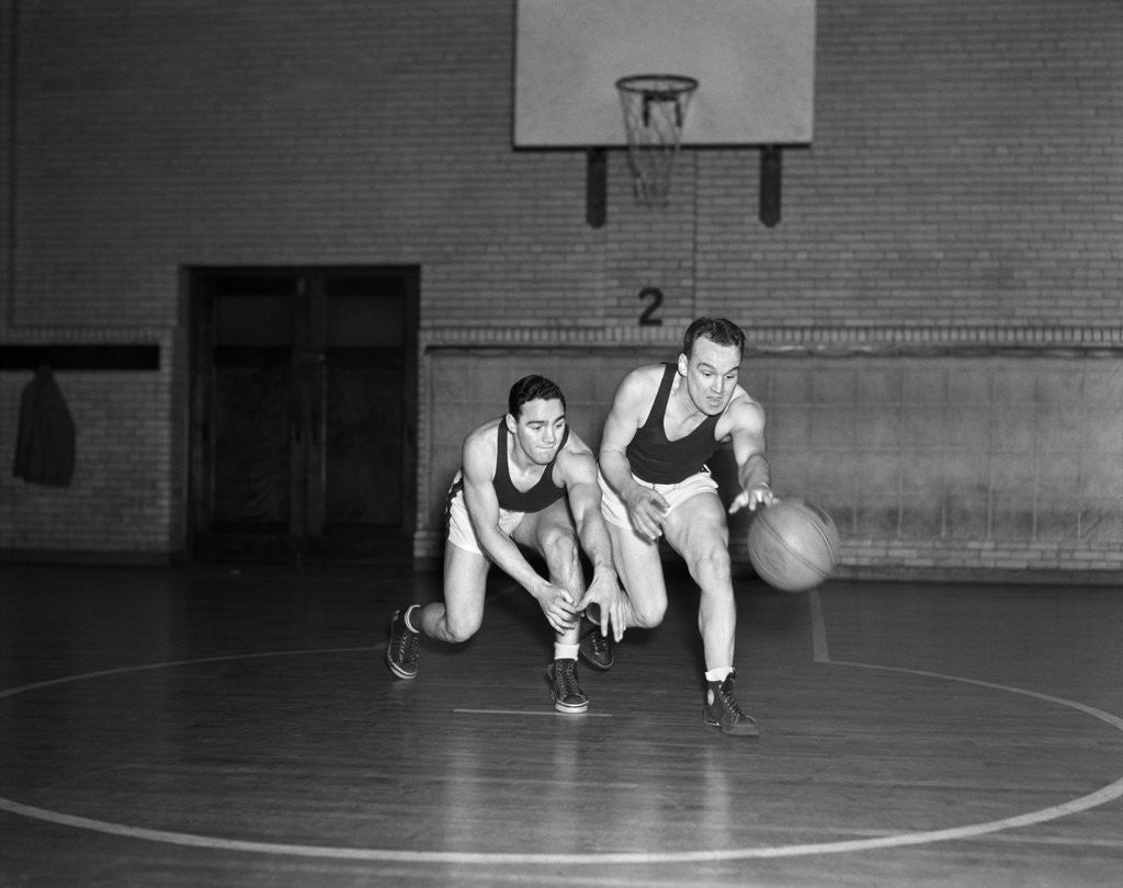 Detail of 1930s two boys playing basketball inside court dribbling basketball by Anonymous