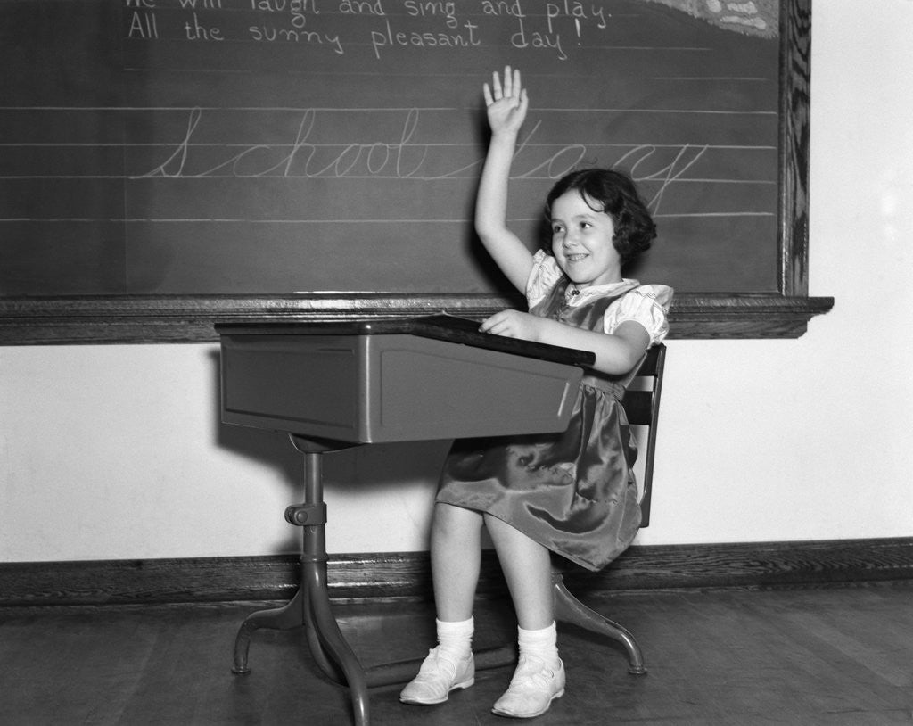 Detail of 1930s 1940s smiling girl sitting at desk raising her hand by Anonymous