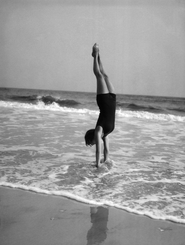 Detail of 1920s woman doing a handstand in ocean surf by Anonymous