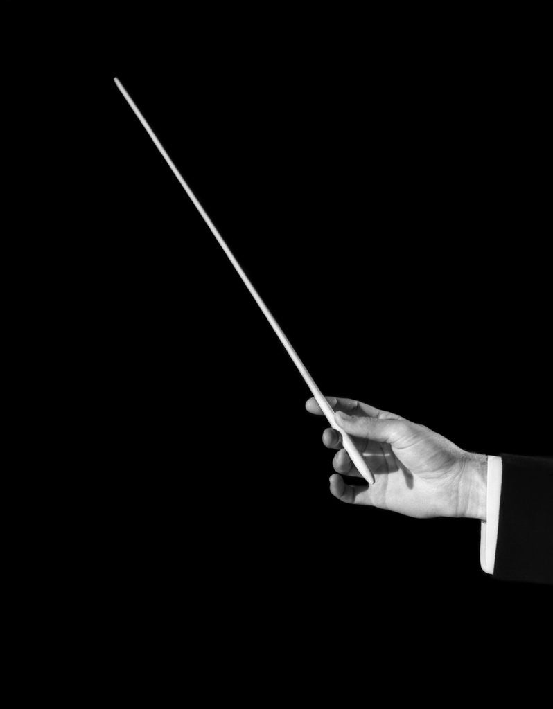 Detail of 1950s male orchestra conductor's hand holding baton by Anonymous