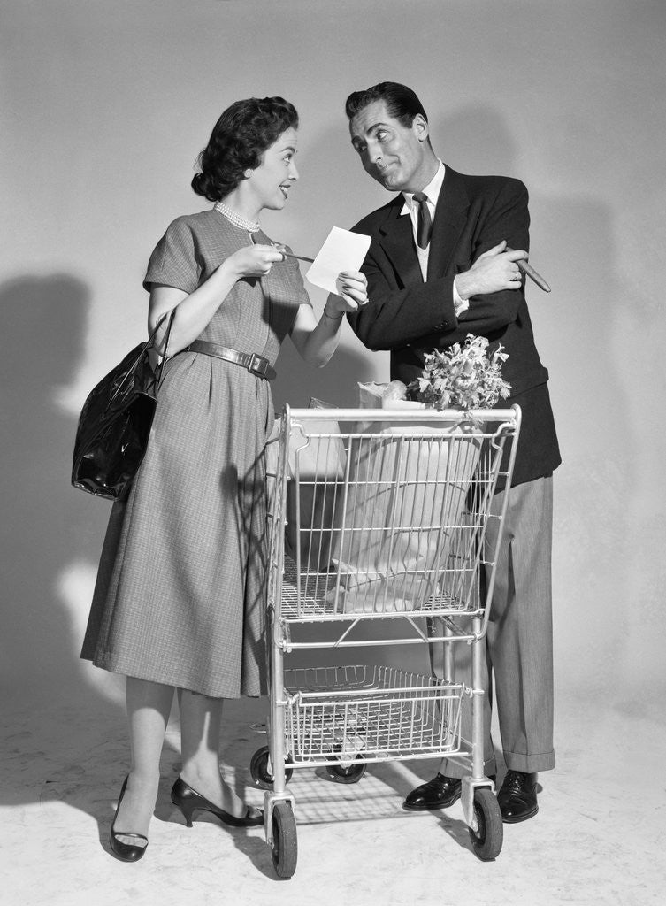 Detail of 1950s couple man woman shopping cart reviewing grocery list man has cigar in hand by Anonymous