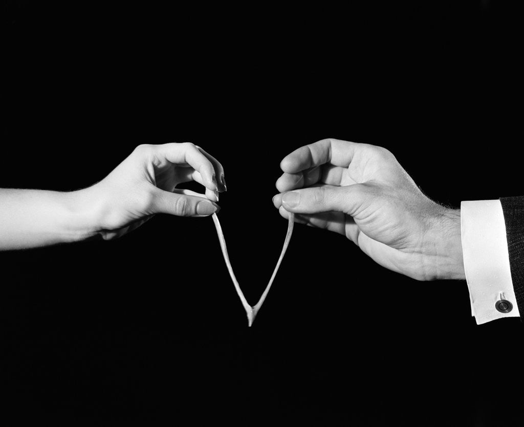 Detail of 1940s man's & woman's hands pulling on either side of wishbone by Corbis