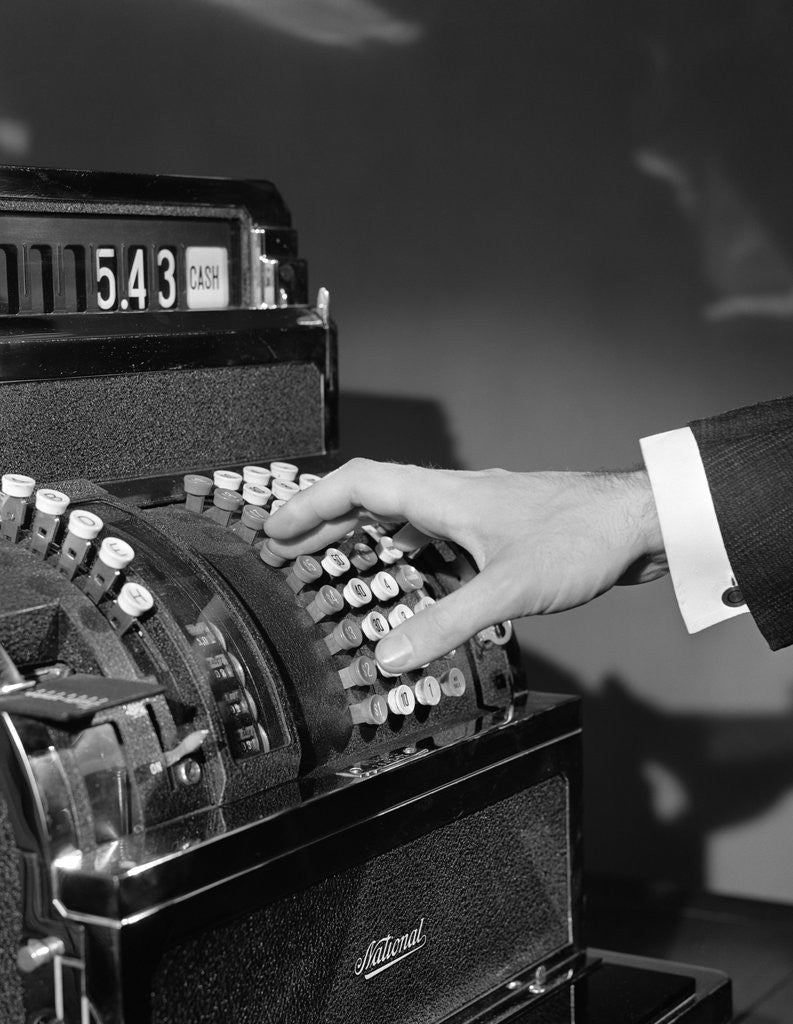 Detail of 1930s 1940s man's hand pushing price buttons on cash register by Corbis