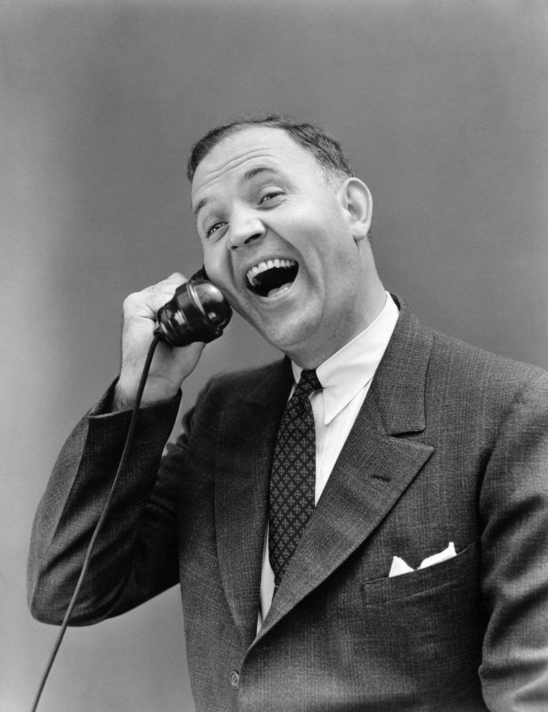 Detail of 1930s man in suit laughing talking on telephone by Anonymous
