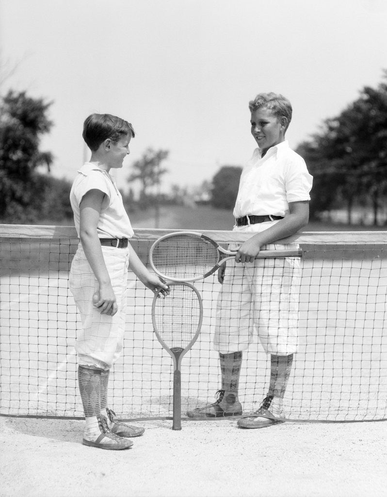 Detail of 1920s 1930s two boys tennis match holding rackets measuring net height by Anonymous