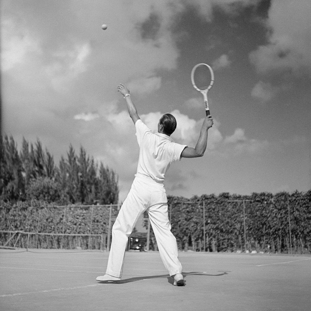 Detail of 1930s back view of man playing tennis about to hit the ball summer outdoor by Anonymous