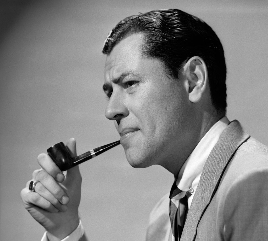 Detail of 1950s frowning businessman in jacket and tie smoking a pipe by Anonymous