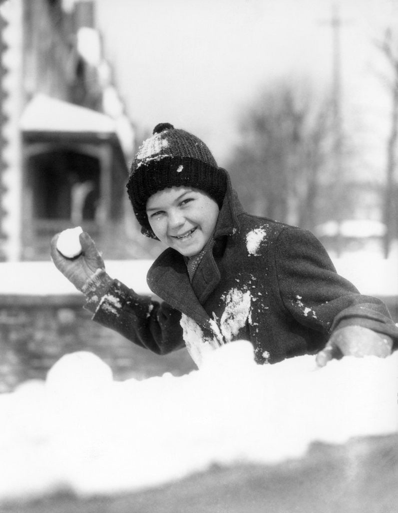 Detail of 1920s 1930s smiling boy about to throw toss snowball playing snow fun winter cold mischief looking at camera by Anonymous