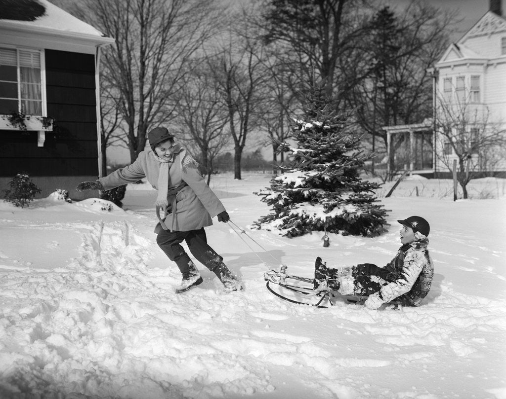 Detail of 1950s woman mother pulling boy son on sled in winter by Anonymous