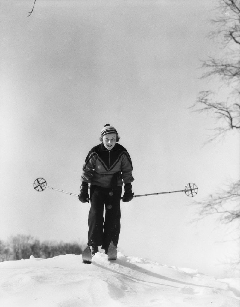 Detail of 1930s woman holding ski poles skiing in snow by Corbis