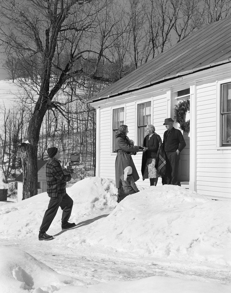 Detail of 1950s family visiting relatives at christmas being greeted at front door by Anonymous