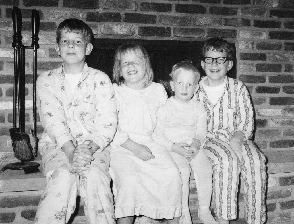 Detail of Siblings perch on a hearth in pajamas, ca. 1970. by Anonymous
