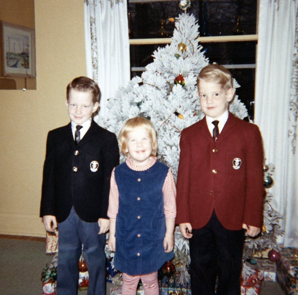 Detail of Dressed up siblings stand by the Christmas tree, ca. 1965. by Corbis