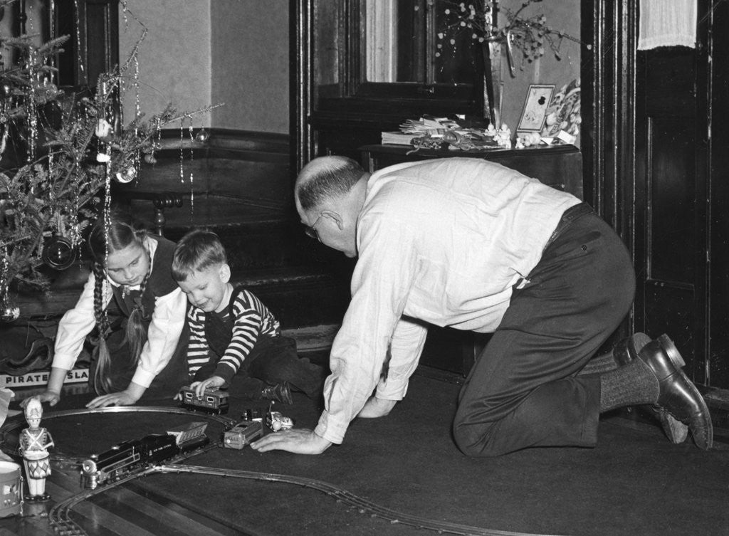 Detail of Dad plays with the kids on Christmas morning, ca. 1950 by Corbis