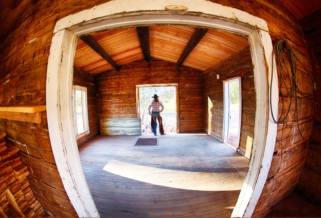 Detail of Cowgirl in doorway of old cabin by Anonymous